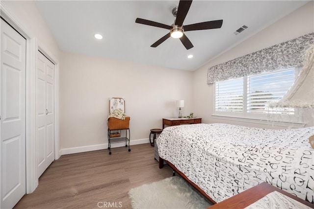 bedroom with wood finished floors, baseboards, visible vents, recessed lighting, and vaulted ceiling