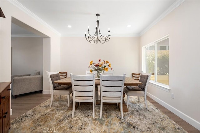 dining area with wood finished floors, recessed lighting, an inviting chandelier, crown molding, and baseboards