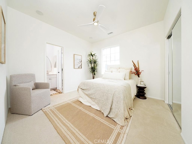 bedroom with visible vents, light carpet, ensuite bath, a closet, and ceiling fan