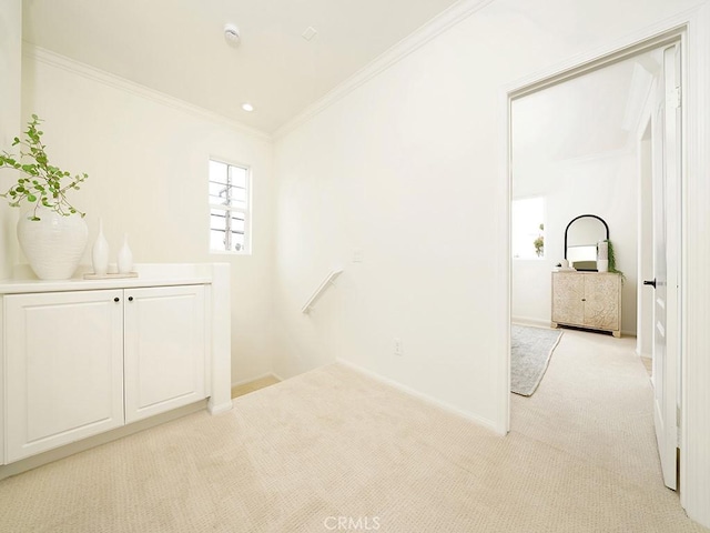 interior space featuring an upstairs landing, light carpet, crown molding, and baseboards