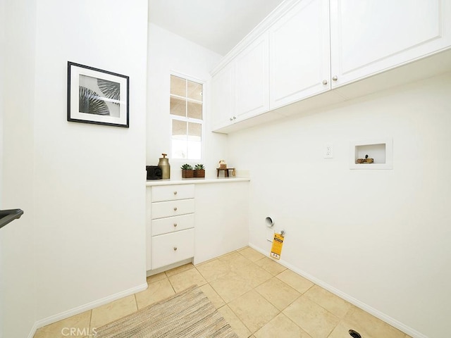 clothes washing area with electric dryer hookup, washer hookup, cabinet space, light tile patterned floors, and baseboards