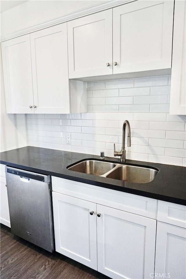 kitchen featuring a sink, dark wood-type flooring, white cabinets, dishwasher, and dark countertops