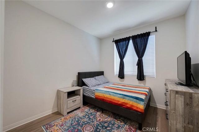 bedroom with baseboards and wood finished floors