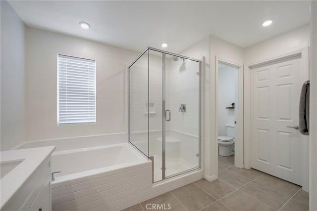 full bath with tile patterned flooring, toilet, a stall shower, a bath, and vanity