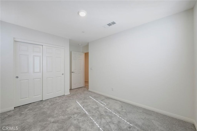 unfurnished bedroom featuring a closet, visible vents, baseboards, and carpet floors