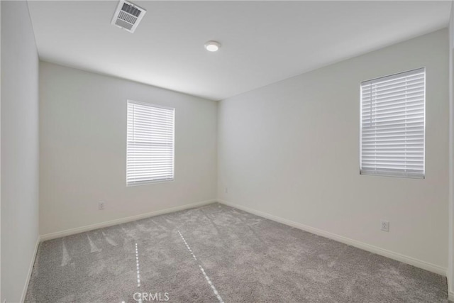 unfurnished room with visible vents, carpet flooring, and baseboards