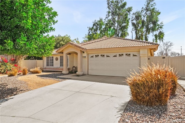 view of front of house featuring an attached garage, fence, driveway, and stucco siding