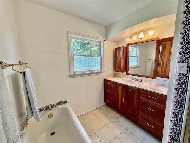 bathroom featuring tile patterned flooring, a bath, vanity, and baseboards