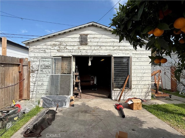 view of outdoor structure featuring an outbuilding and fence