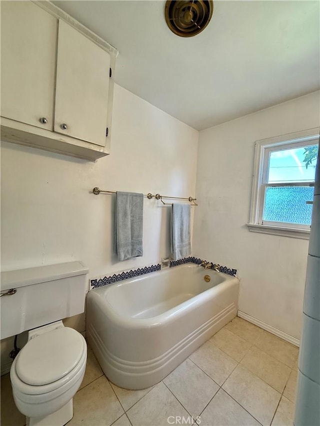 full bath with toilet, tile patterned floors, a bath, and baseboards