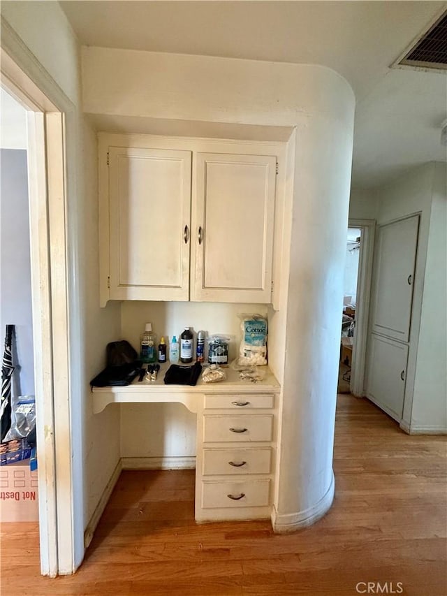 interior space featuring light countertops, light wood-style flooring, visible vents, and white cabinets