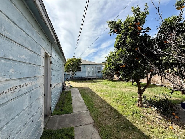 view of yard featuring an outbuilding and fence