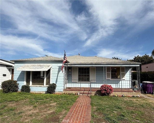 view of front of property featuring covered porch and a front lawn