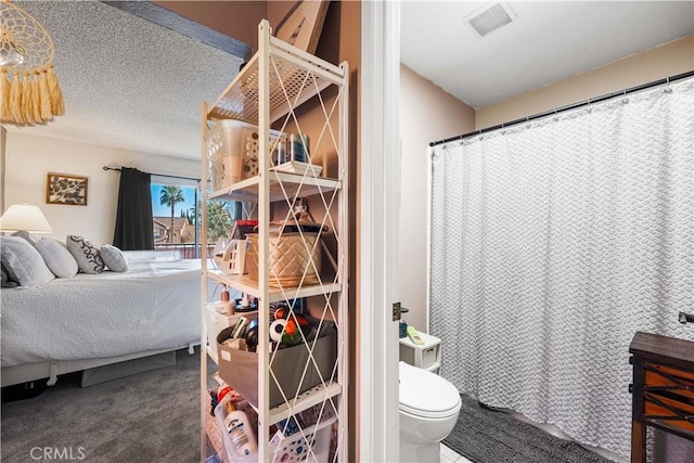 full bath featuring a shower with shower curtain, visible vents, a textured ceiling, and toilet