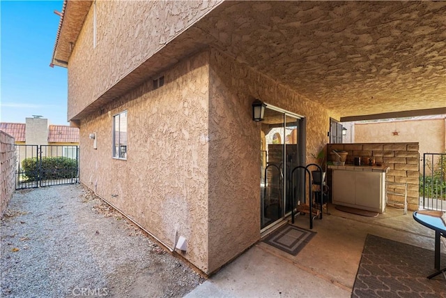 view of property exterior with stucco siding and fence