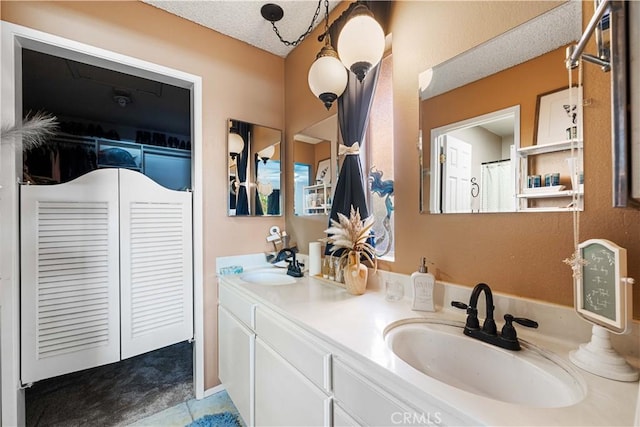 bathroom featuring a textured ceiling, double vanity, tile patterned flooring, and a sink