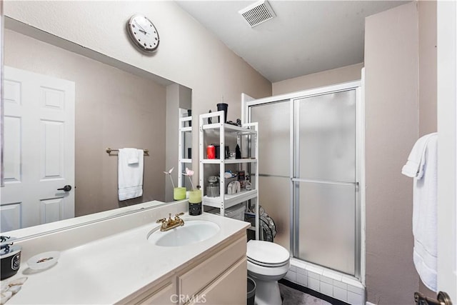 full bath featuring vanity, a shower stall, toilet, and visible vents