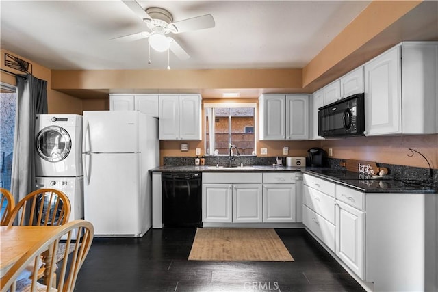 kitchen featuring a sink, black appliances, white cabinets, and stacked washing maching and dryer