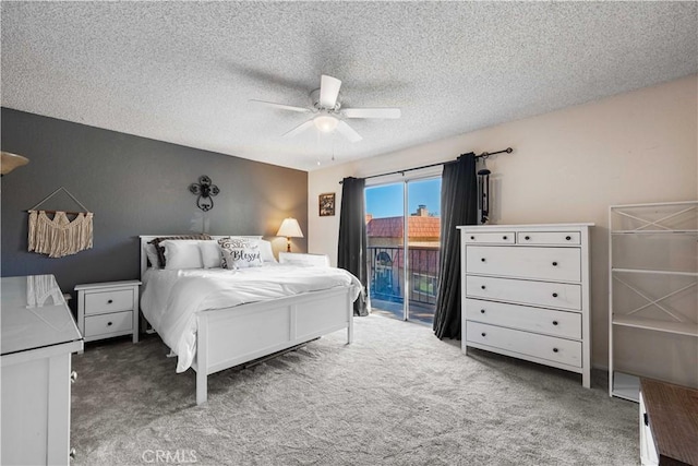 carpeted bedroom featuring a textured ceiling, access to exterior, and a ceiling fan