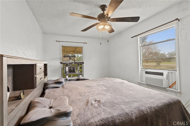 bedroom with cooling unit, a textured ceiling, and ceiling fan