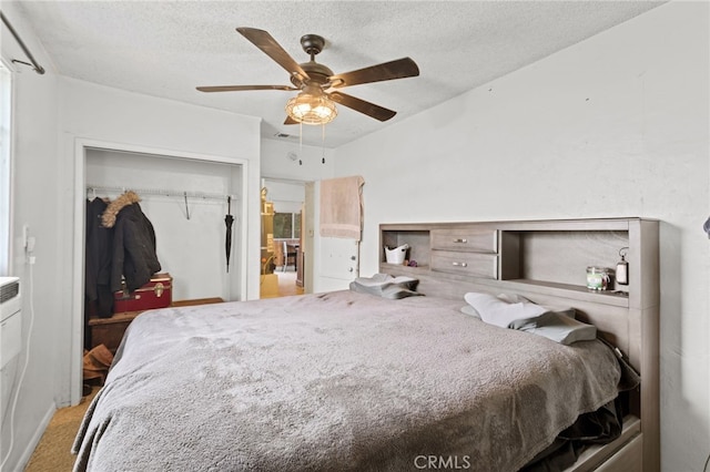 carpeted bedroom featuring a closet, visible vents, a textured ceiling, and a ceiling fan