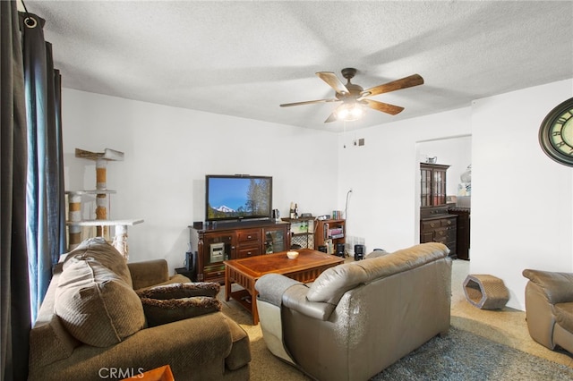 living room with ceiling fan, carpet floors, and a textured ceiling