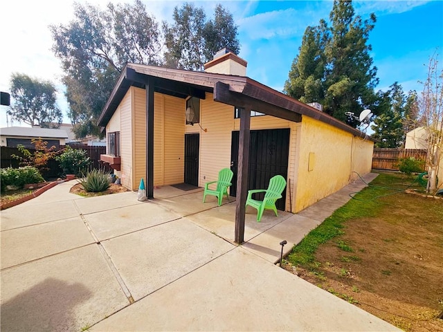 exterior space with a chimney, a patio, and fence