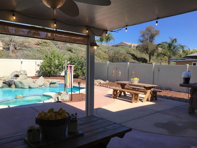 view of patio / terrace featuring a fenced backyard, a fenced in pool, an in ground hot tub, and outdoor dining space