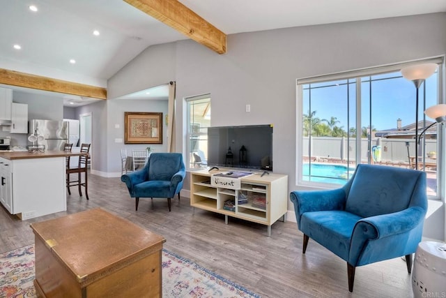 living area featuring lofted ceiling with beams, light wood-type flooring, baseboards, and recessed lighting