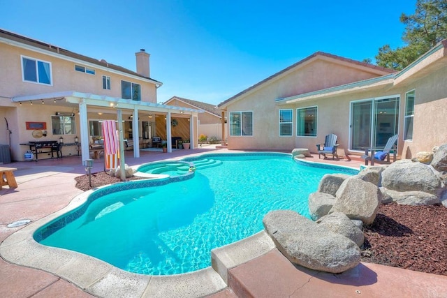 view of pool with a patio area and a pool with connected hot tub