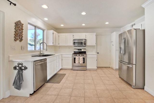 kitchen with a sink, appliances with stainless steel finishes, crown molding, and light countertops