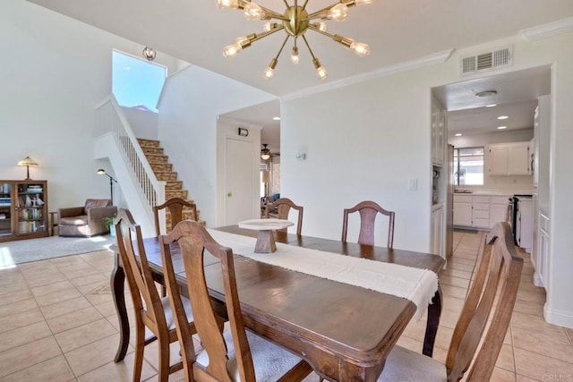 dining room with visible vents, crown molding, stairs, light tile patterned floors, and ceiling fan with notable chandelier