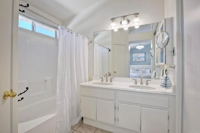 bathroom featuring tile patterned flooring, ensuite bath, double vanity, and a sink