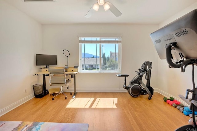 exercise area featuring a ceiling fan, wood finished floors, and baseboards