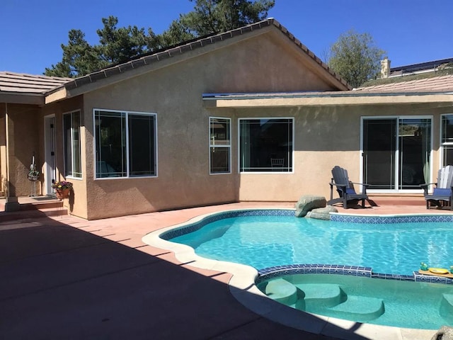 view of pool with a pool with connected hot tub and a patio