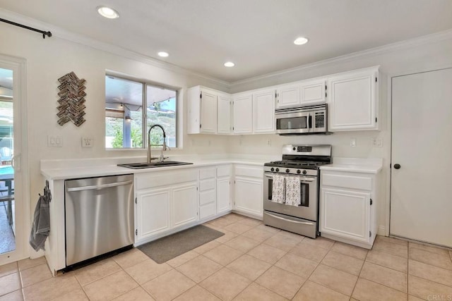 kitchen featuring light countertops, ornamental molding, stainless steel appliances, white cabinetry, and a sink