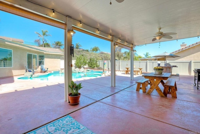 view of patio / terrace featuring outdoor dining area, a fenced in pool, a fenced backyard, and a ceiling fan