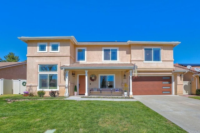 view of front facade featuring a front yard, fence, driveway, covered porch, and stucco siding