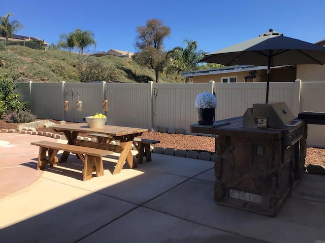 view of patio with outdoor dining area, fence, and a grill