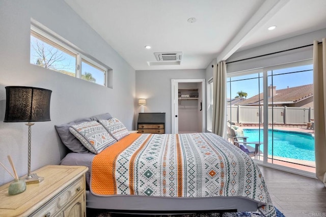 bedroom featuring visible vents, multiple windows, wood finished floors, and access to outside