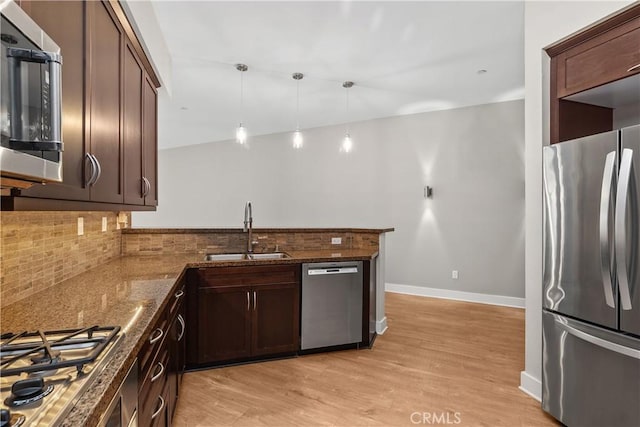 395 E 4th Unit 25, Long Beach, CA 90802 - kitchen featuring appliances with stainless steel finishes, a sink, decorative backsplash, light wood-style floors, and a peninsula