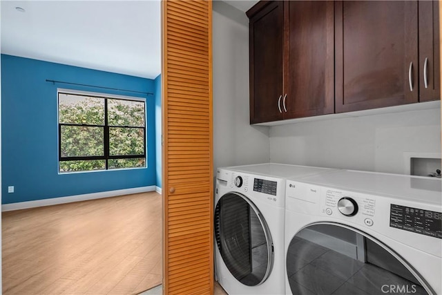 laundry room with light wood finished floors, cabinet space, baseboards, and separate washer and dryer