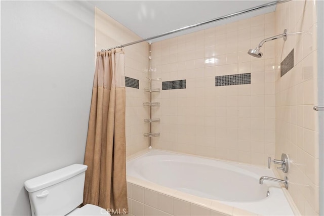 bathroom featuring toilet and tiled shower / bath