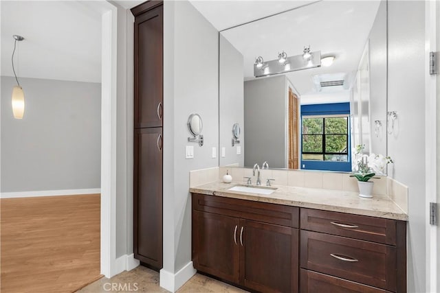 bathroom featuring vanity, baseboards, and wood finished floors