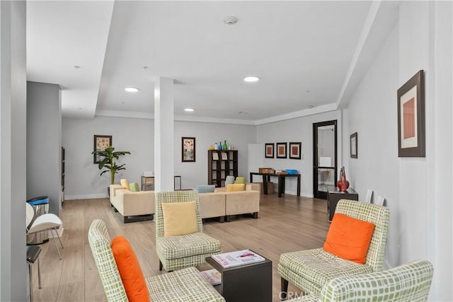 living room featuring recessed lighting, light wood-type flooring, baseboards, and ornamental molding