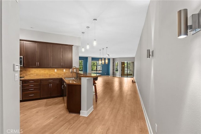 395 E 4th Unit 25, Long Beach, CA 90802 - kitchen with a sink, a kitchen breakfast bar, open floor plan, tasteful backsplash, and a peninsula