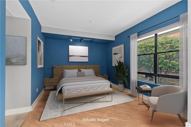 395 E 4th Unit 25, Long Beach, CA 90802 - bedroom featuring baseboards, wood finished floors, and rail lighting