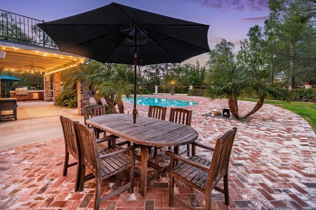 35715 Calle Nopal, Temecula, CA 92592 - patio terrace at dusk featuring a patio area, outdoor dining area, a balcony, an outdoor kitchen, and ceiling fan