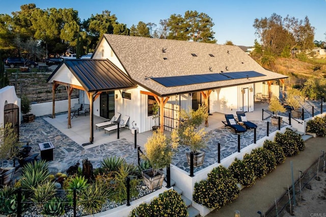 35715 Calle Nopal, Temecula, CA 92592 - rear view of house featuring a fenced backyard, a patio area, solar panels, board and batten siding, and a standing seam roof