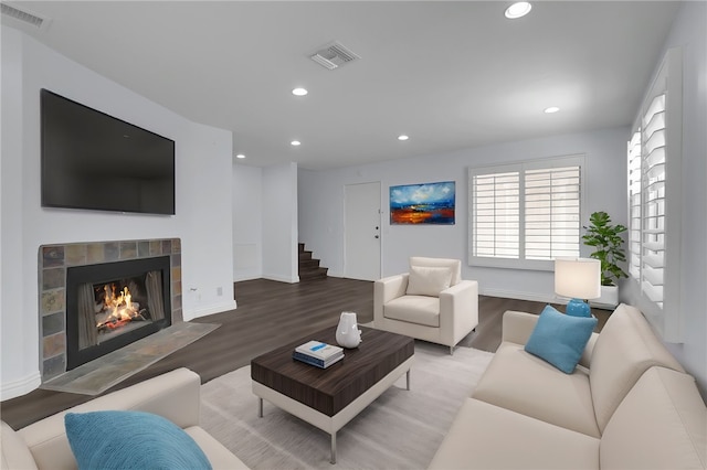 living room with recessed lighting, wood finished floors, visible vents, and a tile fireplace